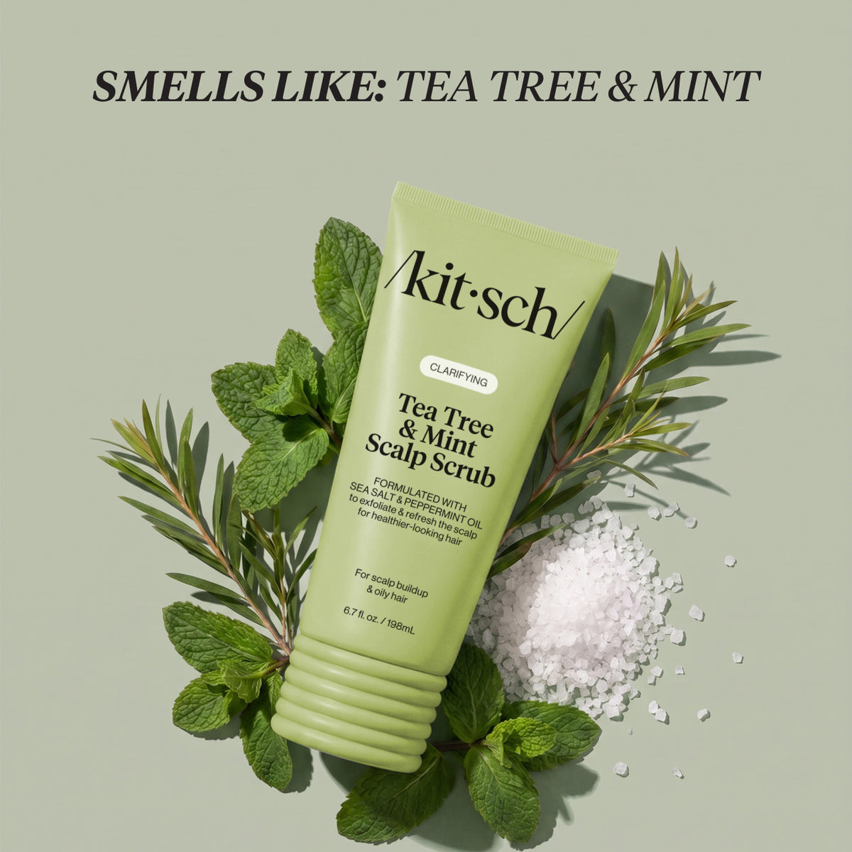 KITSCH Clarifying Tea Tree & Mint Scalp Scrub — the tube resting on mint leaves, tea tree sprigs and sea salt — Smells like tea tree & mint for an energizing experience every time — a refreshing shower