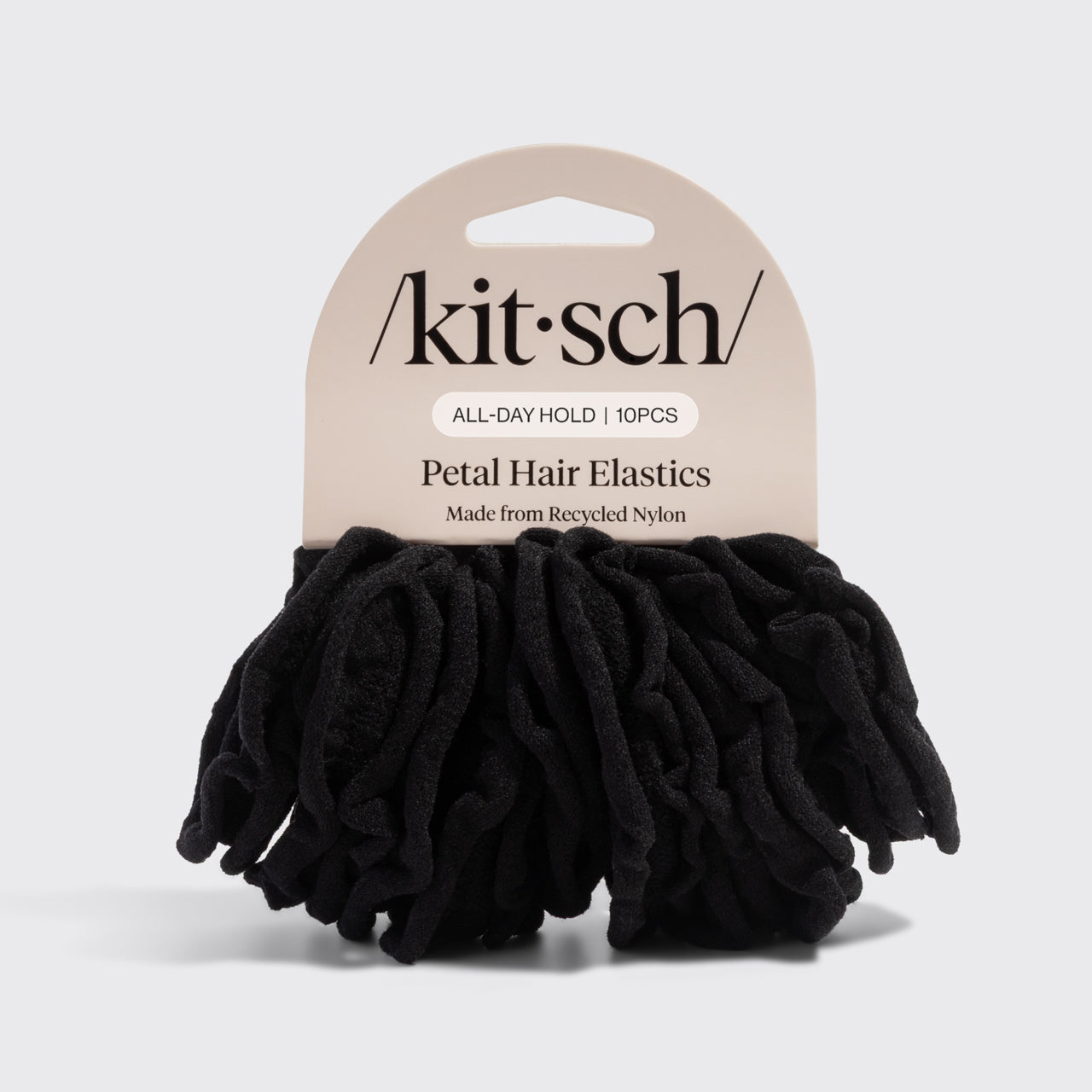 Kitsch black petal hair elastics in their packaging on a light gray background