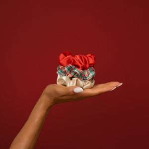 KITSCH Red & Gold Holiday Scrunchies 3pc Set — open palm holding all three scrunchies against a deep red backdrop — Soft fabric provides a gentle hold — cozy holiday days