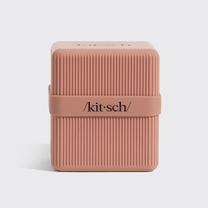 KITSCH 2-Compartment Travel Case Terracotta — side product shot on white background showcasing ribbed texture — /kit·sch/ branding on center band — closed case showing durable terracotta construction — Sleek, durable & lightweight for stress-free travel — TSA-approved size allows for effortless travel with your beauty essentials — Eco-friendly; made from 100% recycled plastic